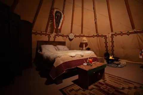 Queen bed with gas fireplace at Woodland Tipi, Sandpoint Idaho