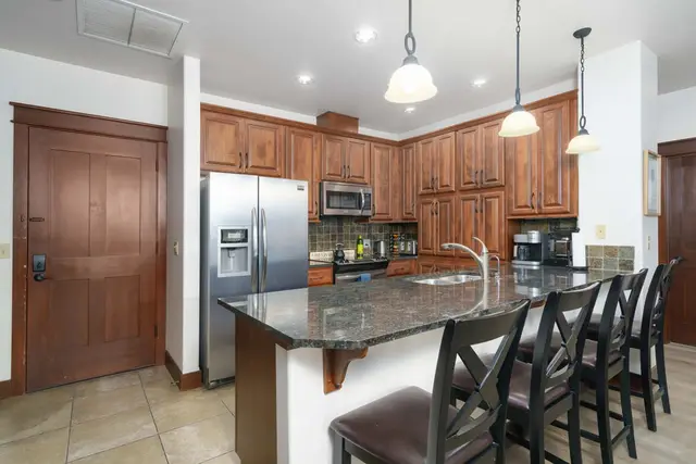 An open kitchen with counter seating keeps the cook connected to the conversation at Riverstone Village Retreat, Coeur d'Alene Idaho