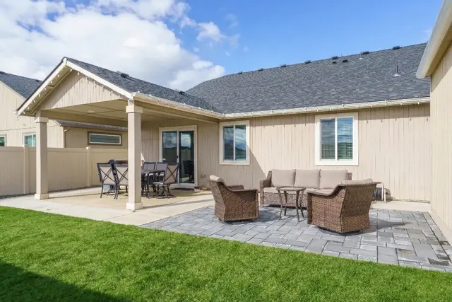 Dine al fresco on the covered patio, where shaded seating invites long summer dinners at Pine and Vine Cottage, Rathdrum Idaho