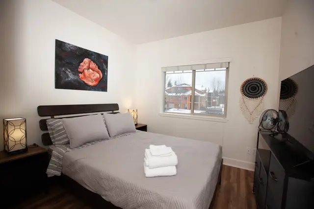 Second bedroom with queen bed, nightstands, lamps, artwork and dresser at Pheasant Run Condo, Coeur d'Alene Idaho