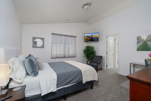 Unwind in the serene primary bedroom, where a plush bed dressed in soft linens at Pine and Vine Cottage, Rathdrum Idaho