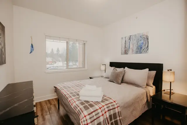 First bedroom with Queen bed, nightstands, lamps, and artwork at Pheasant Run Condo, Coeur d'Alene Idaho