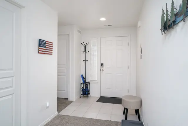 Step inside to a bright, welcoming entryway with a coat rack and drop spot for shoes at Pine and Vine Cottage, Rathdrum Idaho